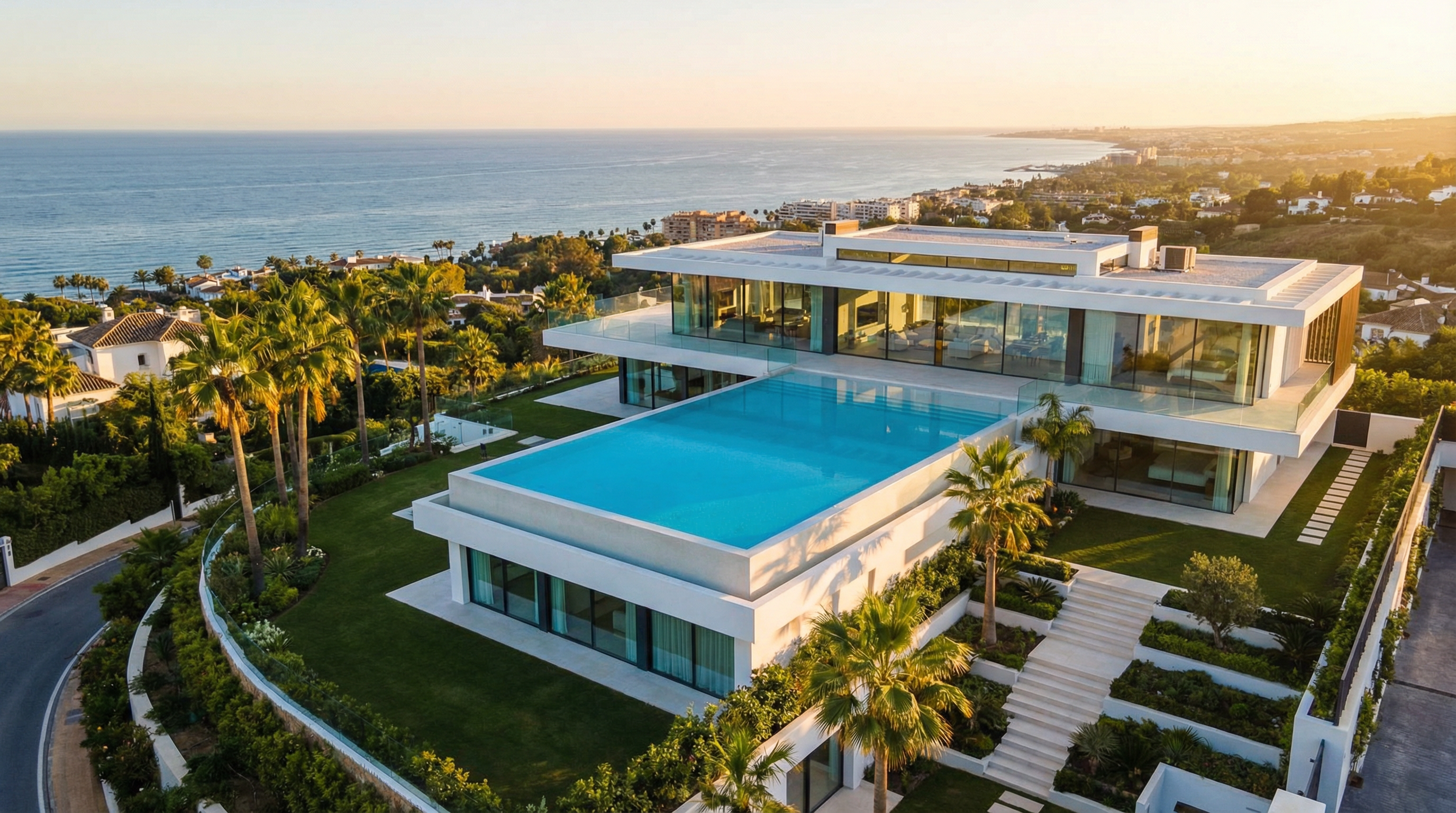 Luchtfoto van een luxe villa in Marbella met moderne architectuur, een infinity pool en uitzicht op de Middellandse Zee, omringd door weelderige natuur.