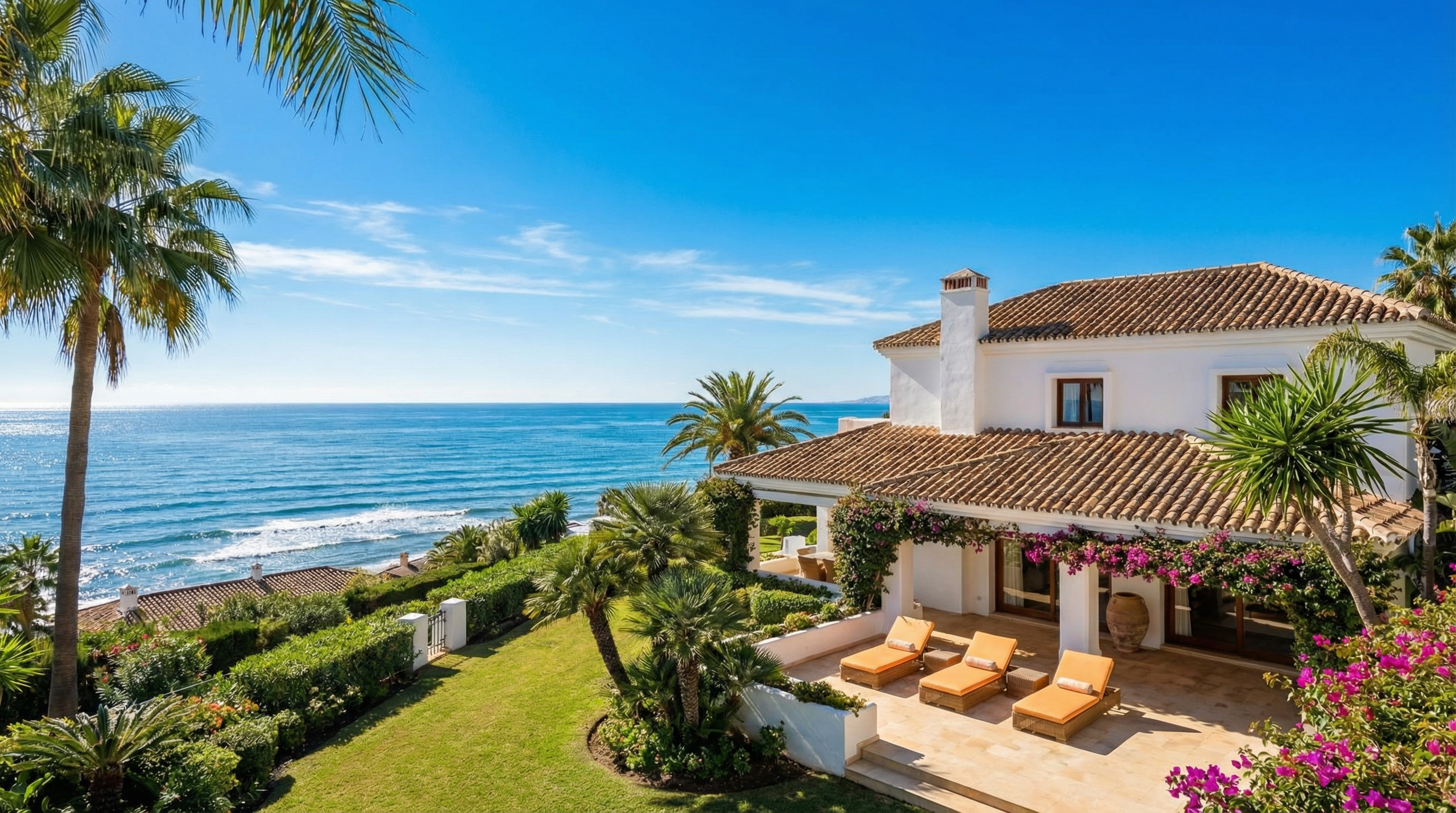 Panoramic view of Costa del Sol coastline on a sunny winter day, featuring a luxurious villa with whitewashed walls and blooming bougainvillea.
