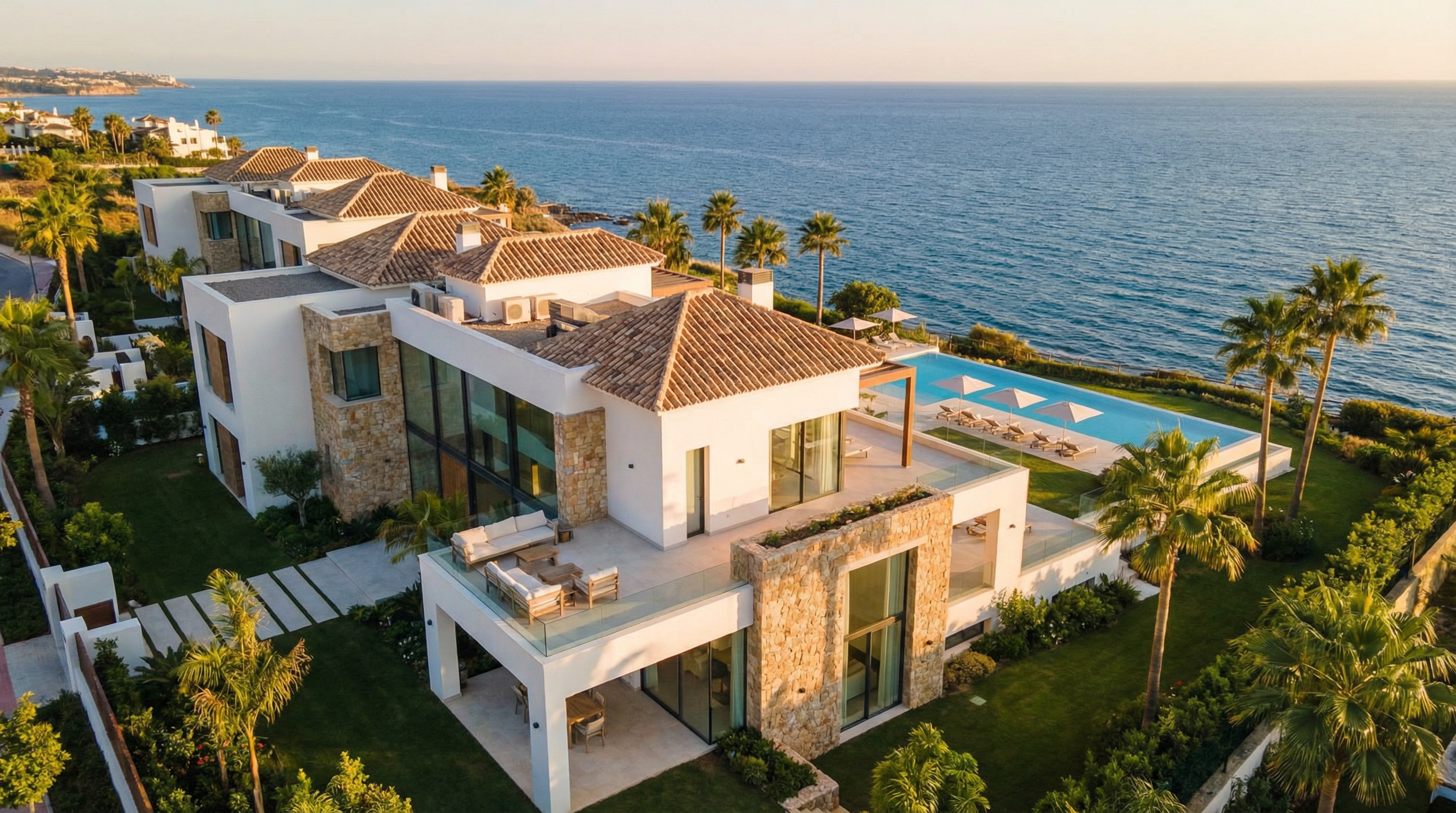 Vue aérienne d'une résidence de luxe sur la Costa del Sol, mettant en valeur l'architecture méditerranéenne moderne, la mer Méditerranée et des jardins soignés.