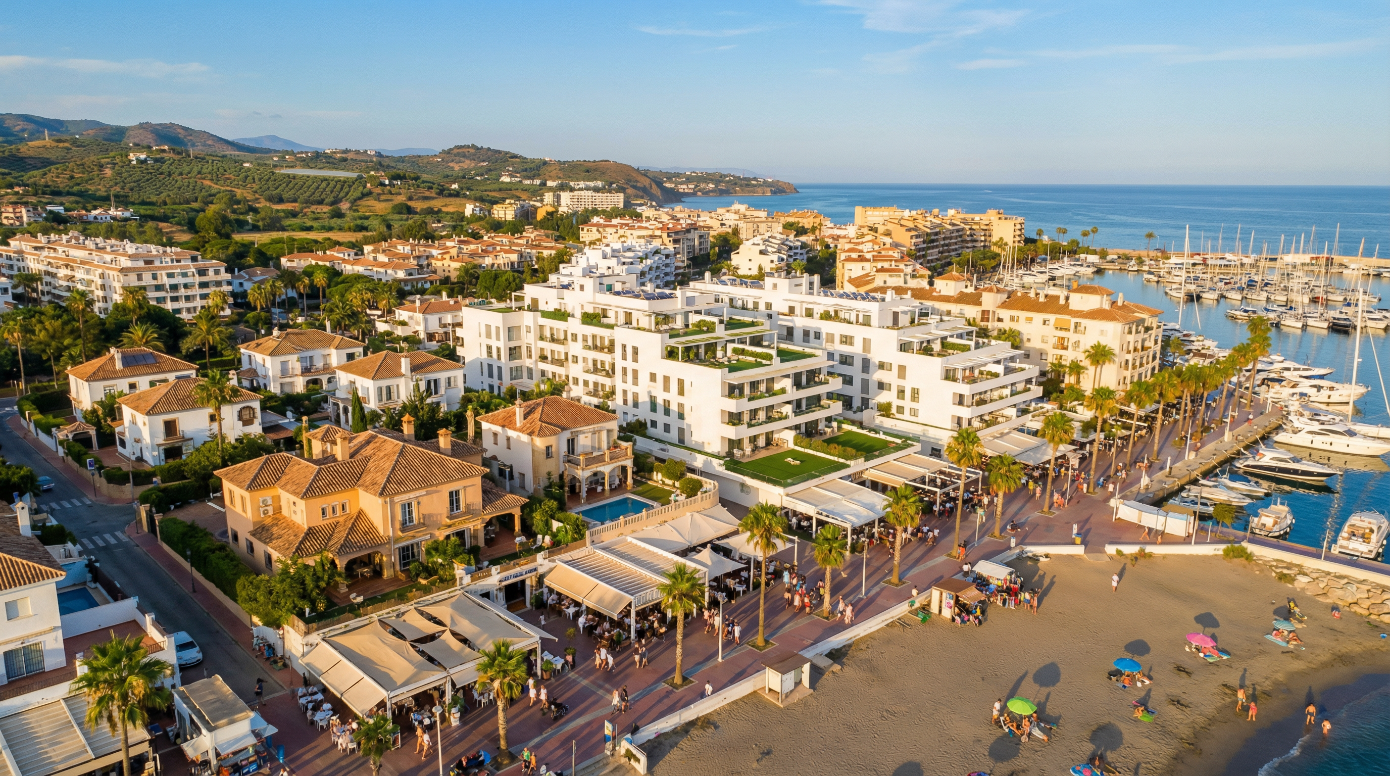 Widok z lotu ptaka na tętniącą życiem nadmorską miejscowość na Costa del Sol, z nowoczesną architekturą i bujną zielenią.