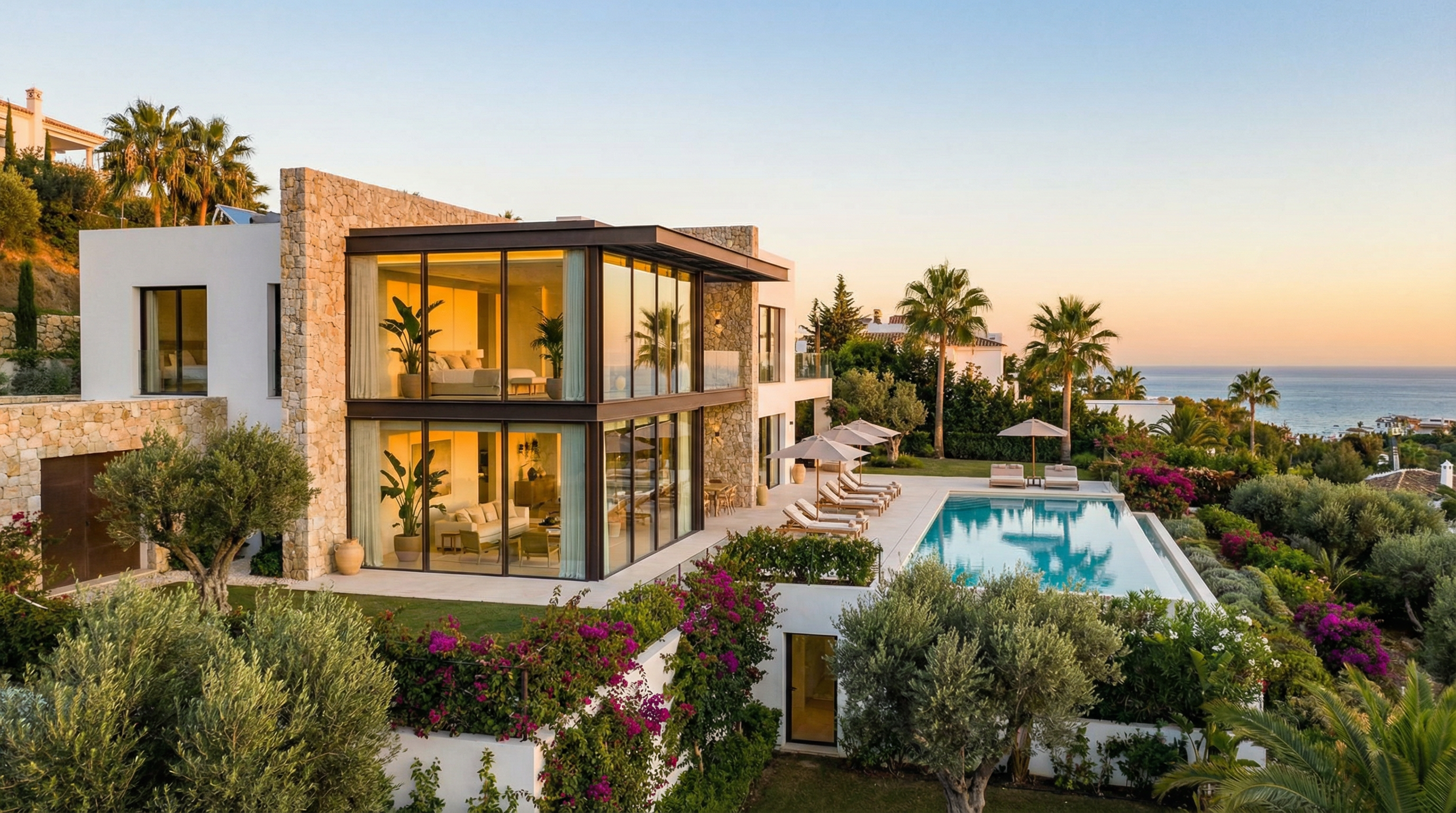 Moderne villa i Costa del Sol med elegant facade, store vinduer og luksuriøs udendørs terrasse med swimmingpool og udsigt til Middelhavet.