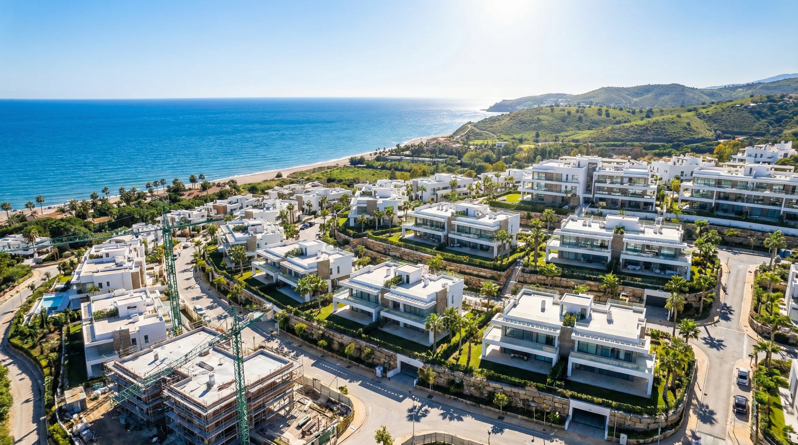 Aerial view of modern off-plan property development in Costa del Sol, showcasing sleek architecture against the Mediterranean landscape.