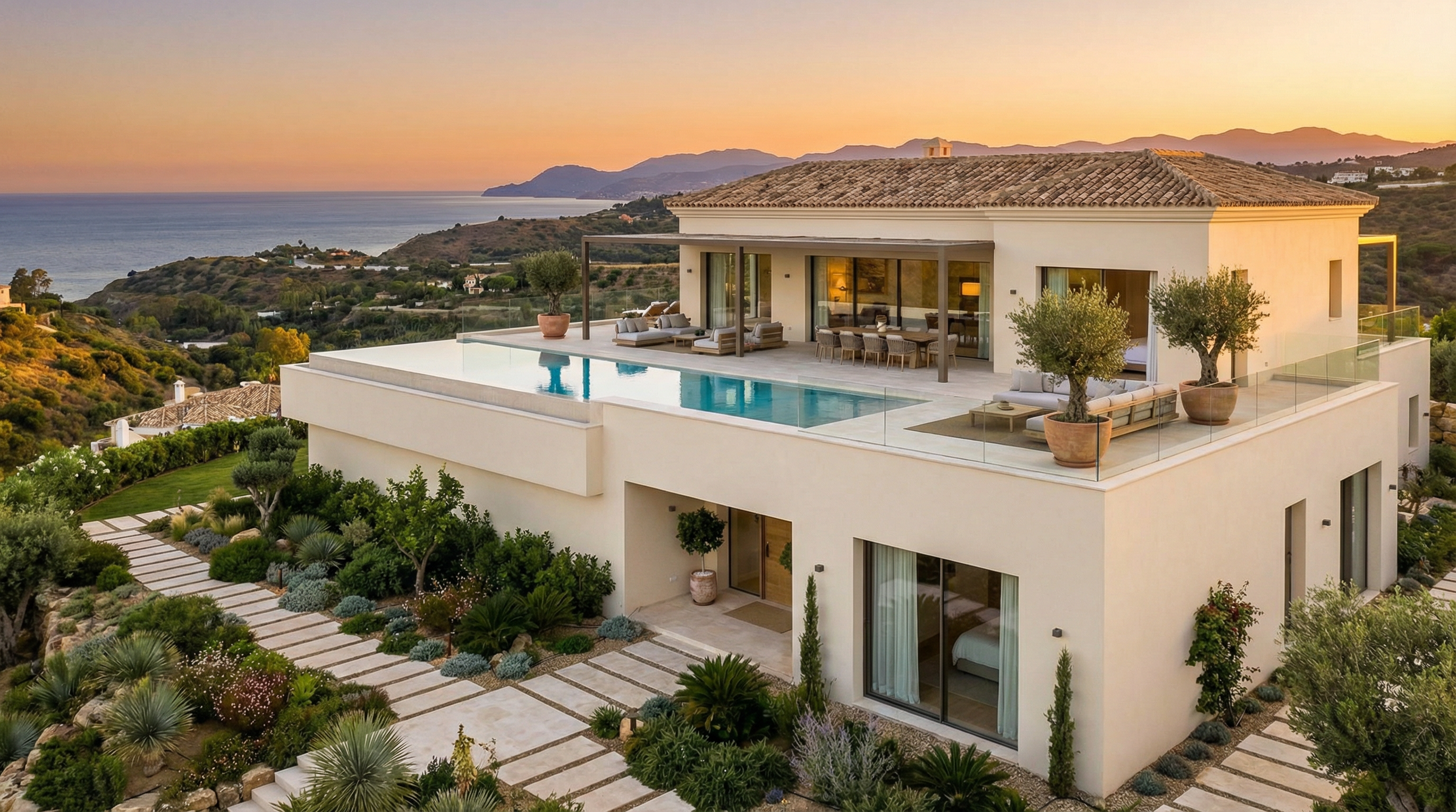 Eine moderne mediterrane Villa an der Costa del Sol, die elegante Architektur, üppige Gärten und eine ruhige Außenterrasse unter einem leuchtend blauen Himmel zeigt.