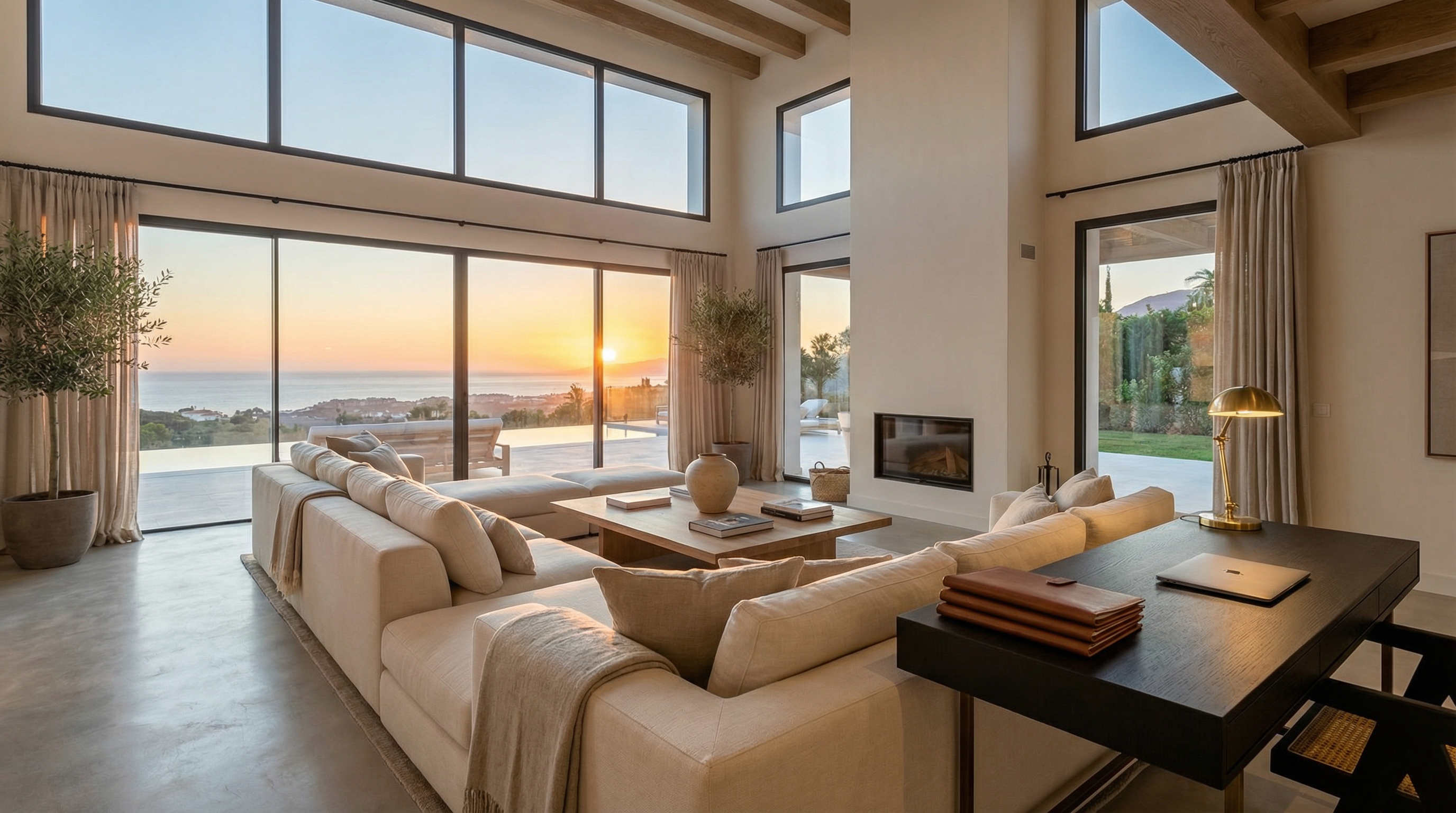 Elegant interior of a modern Costa del Sol property with large windows, showcasing a sunset view of the Mediterranean, emphasizing luxury and legal security.
